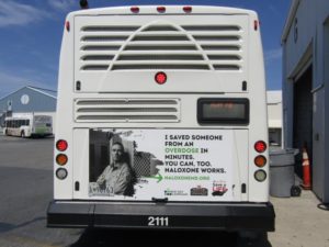 Picture of the New Day Campaign Naloxone series on the back of a bus with the quote "I saved someone from an overdose in minutes. You can, too. Naloxone works."